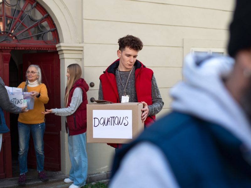 Diverse group of volunteers with donation boxes standing outdoors, social care and charity concept Diverse group of volunteers with donation boxes standing outdoors, social care and charity concept